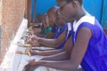 우간다의 한 학교에서 어린이들이 수업 시작에 앞서 손을 씻고 있다